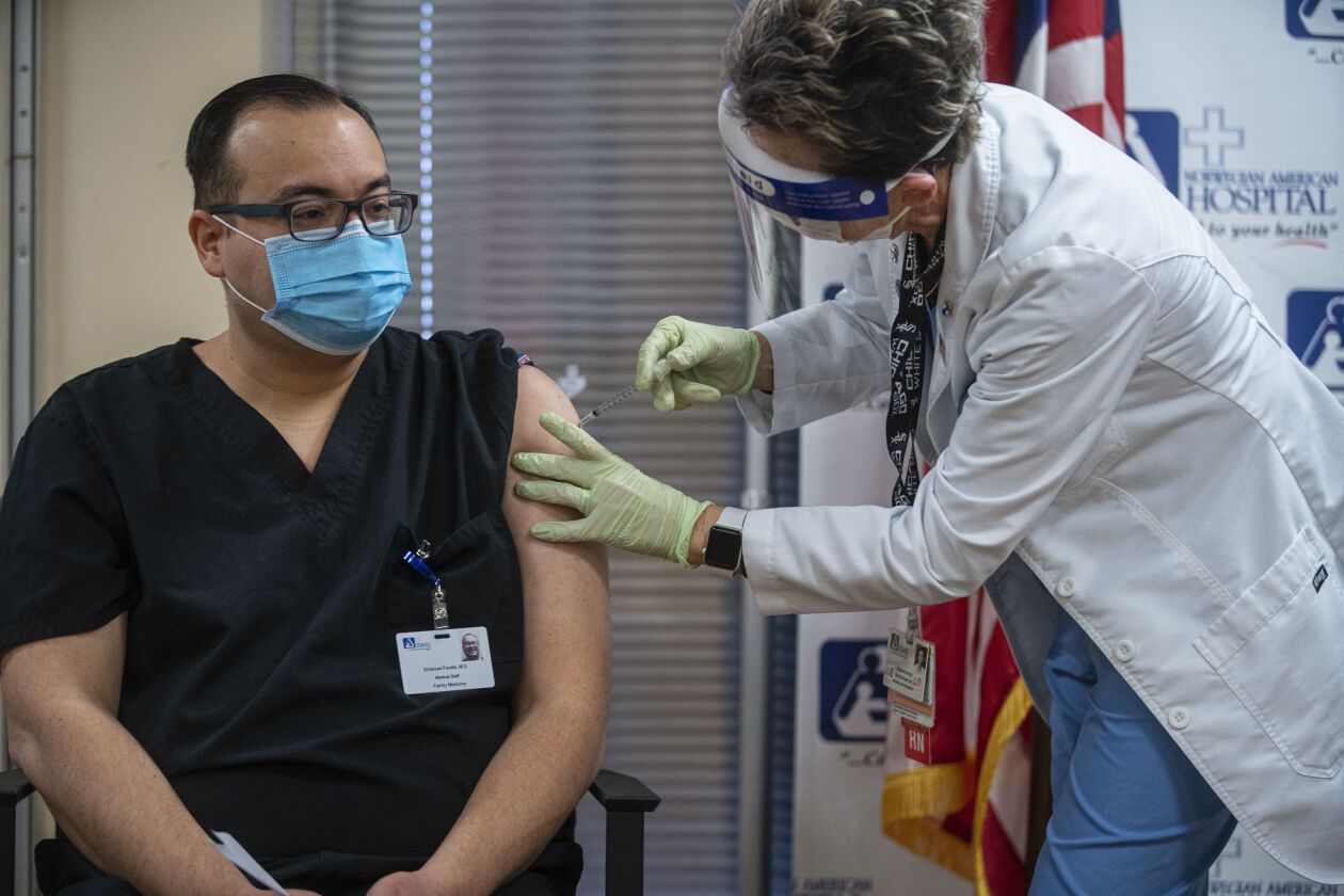 Dr. Emanuel Favela is vaccinated at a news conference at Norwegian American Hospital in Humboldt Park n December of 2020.